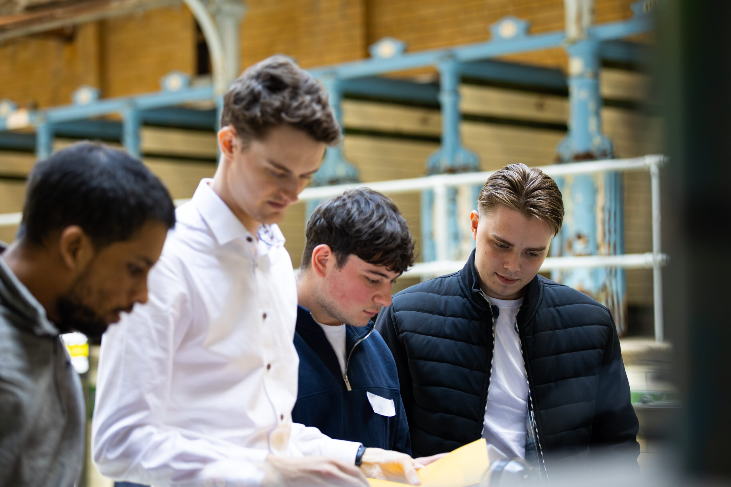 4 men looking intently at a cyber escape room